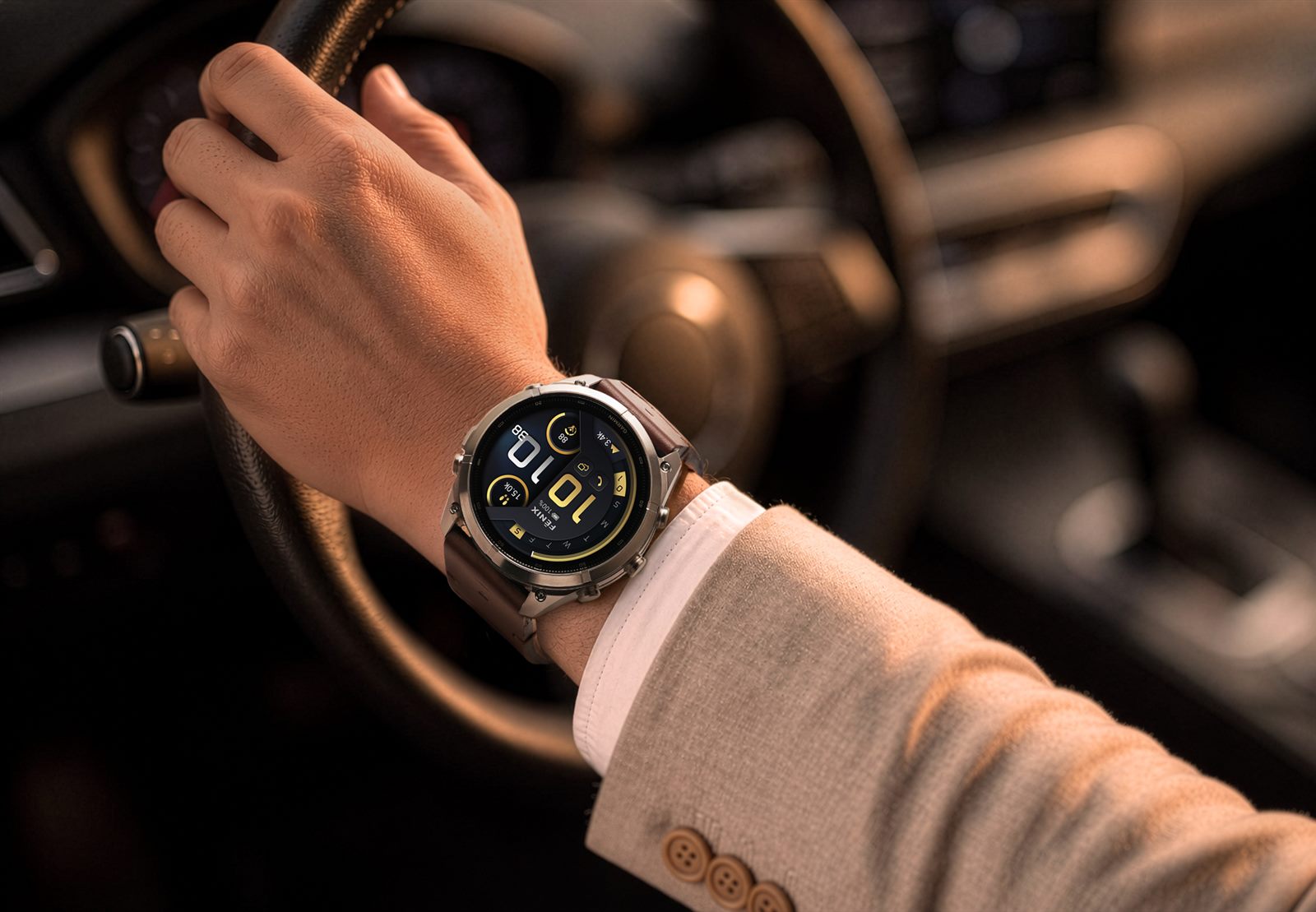 配戴 Garmin fenix 9 Pro 鈦金屬錶殼與皮革錶帶，手握方向盤